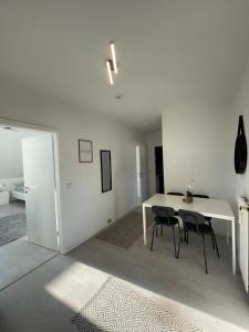 a white dining room with a table and chairs at Premium Apartment 3 in Dillingen an der Saar