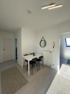 a white dining room with a white table and chairs at Premium Apartment 3 in Dillingen an der Saar