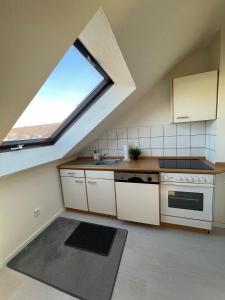 an attic kitchen with a sink and a window at Premium Apartment 3 in Dillingen an der Saar