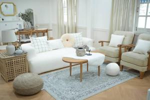 a living room with a white couch and two chairs at heaven in Ban Bang Phai