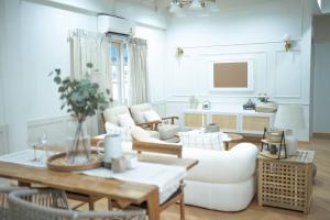 a living room with white furniture and a table at heaven in Ban Bang Phai