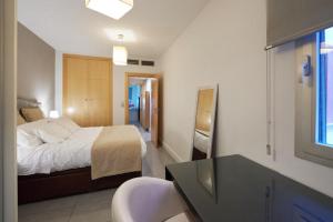 a bedroom with a bed and a desk and a window at Vivir en el Campus de la Salud in Granada