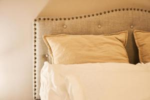 a close up of a bed with white sheets and pillows at Vivir en el Campus de la Salud in Granada