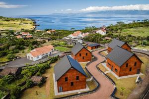 una vista aérea de un pueblo con casas y agua en Cabanas do Pico 1B, en Canto da Areia