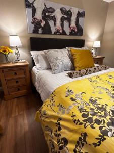a bedroom with a bed with a yellow comforter at Lemonade Cottages and Retreat in Kilrush