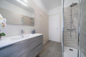 a bathroom with a sink and a shower at Marino's Apartment in Udine +18 photos