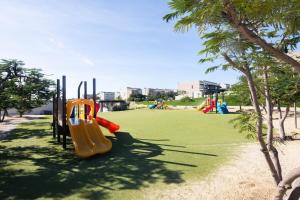 a playground with a slide in a park with trees at Escapada Serena in Cabo San Lucas