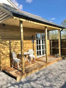 a cabin with a table and two chairs on a deck at Fairway Lodge in Saint Erth