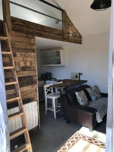 een kamer met een bank, een bureau en een ladder bij Fairway Lodge in Saint Erth