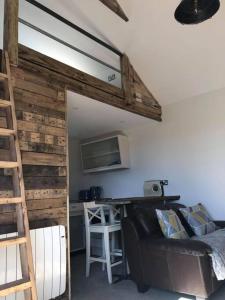 a room with a loft bed and a kitchen with a bar at Fairway Lodge in Saint Erth