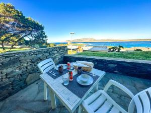 a table and chairs on a patio with a view of the ocean at Residence Hotel La Pelosetta in Stintino