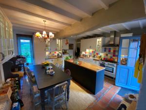 una cocina con mesa y una isla azul en Immaculate 6 plus Bed Villa with pool in Sarron, en Sarron