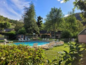 a swimming pool with lounge chairs in a yard at 17 Gites famille,OU 2 Gites avec Spa, Piscine, Restaurant, 4KM de Conques,Navette sur Demande in Conques-en-Rouergue