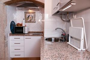 una cocina con fregadero y microondas en Casa do Briamante 6, en Sintra 18 fotos más