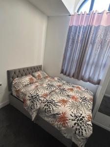 曼徹斯特的住宿－Lovely 1 bed apartment in Salford，一间卧室配有床、被子和窗帘