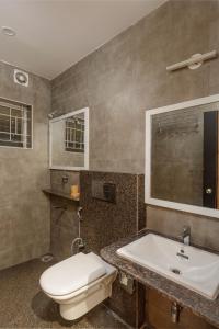 a bathroom with a toilet and a sink at Classic Heights Serviced Apartments, near IIM Bangalore, in Bengaluru