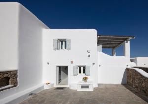 a white house with white walls and windows at Villa Lucia kalafati area in Kalafatis