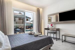 a bedroom with a bed and a view of a balcony at BLUE STAR APARTHOTEL in Nydri