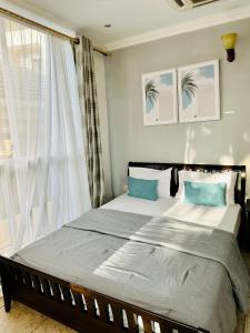 a bedroom with a large bed and a window at Ocean Oasis 2Br Condo in Dar es Salaam