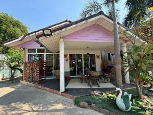 uma pequena casa rosa com uma mesa e cadeiras em Crypto Resort - Koh Larn em Ko Larn