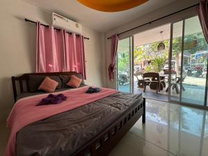 Un dormitorio con una cama con sábanas rosas y una gran ventana. en Crypto Resort - Koh Larn en Ko Larn