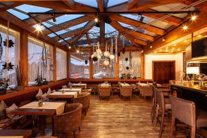 un restaurante con suelo de madera, mesas y sillas en Boutique Hotel die Mittagspitze Superior, en Damüls