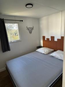 Camping Beaussement LIBERTY climatisé في Chauzon: غرفة نوم بسرير ازرق كبير مع نافذة
