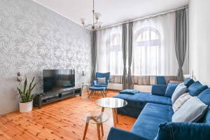 uma sala de estar com um sofá azul e uma televisão em Przestronne mieszkanie w centrum Gdańska em Gdansk