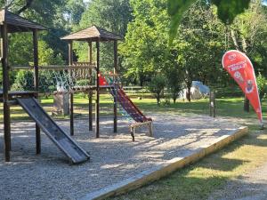 a playground with a slide in a park at Camping Beaussement LIBERTY climatisé in Chauzon