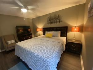 Red Door North Jackson-Ridgeland Vacation Home في جاكسون: غرفة نوم بسرير وتلفزيون ومصباحين