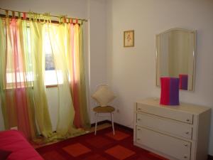 a bedroom with a dresser and a window with a mirror at Apartamento Aracelli in Ermesinde