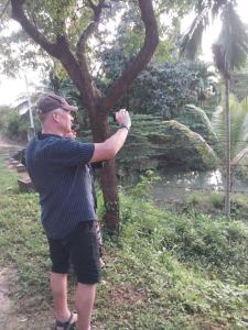 a man is standing next to a tree at Ridge Boundary View in Dambulla