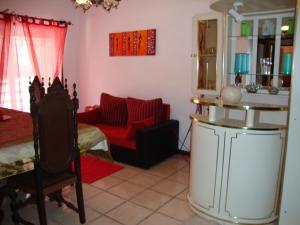 a living room with a red couch and a table at Apartamento Aracelli in Ermesinde