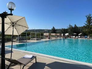 una gran piscina con una silla y una sombrilla en FLOATING SEA HOUSE AURORA en Portorož