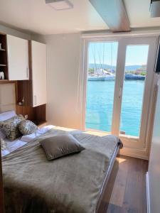 a bedroom with a bed with a view of the water at FLOATING SEA HOUSE AURORA in Portorož