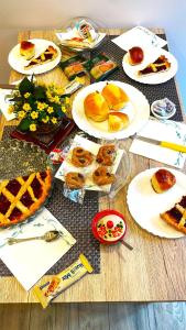 una mesa con platos de repostería y pasteles. en Casa AGNESE B&B, en Nápoles
