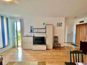 a living room with a television and a refrigerator at SOLITA Apartment with Panoramic View in Byala +13 photos