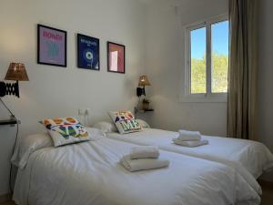 ein weißes Schlafzimmer mit einem großen weißen Bett mit Kissen in der Unterkunft Nerja Paradise Rentals - Apt Chimenea C2D in Nerja + 19 Fotos