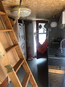 a room with a bunk bed and a ladder at Tiny house for 2 with private garden in Utrecht