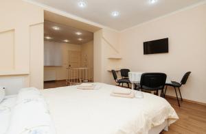 ein Schlafzimmer mit einem weißen Bett sowie einem Tisch und Stühlen in der Unterkunft Vieru in Chişinău