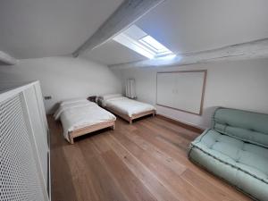 Cette chambre comprend deux lits et un canapé. dans l'établissement Garofoli Apartments, à San Giovanni Lupatoto