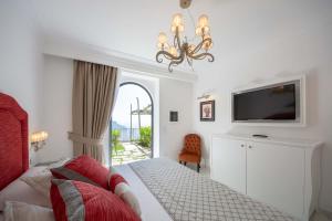 a bedroom with a bed and a flat screen tv at Villa Amore in Ravello