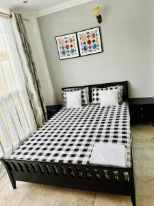 a black and white bed in a room at Ocean Oasis 2Br Condo in Dar es Salaam
