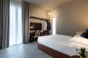 a bedroom with a bed and a desk and a television at Homie in Rimini