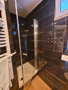 baño con ducha de azulejos negros en Domek na Pagórku, en Lwówek Śląski