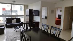 uma sala de estar com mesa e cadeiras e uma sala de estar em Blaumer Apartamentos - Edificio Aguila Dorada em Punta del Este
