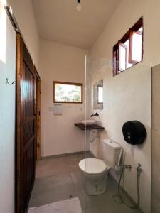uma casa de banho com um WC e uma cabina de duche em vidro. em OXE hostel em Morere