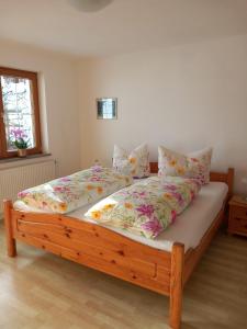 - une chambre avec un grand lit fleuri dans l'établissement Haus am Waldrand, à Thiersee
