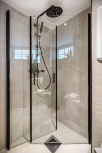 een douche met een glazen deur in de badkamer bij Det grønne huset i Verftsgaten in Bergen