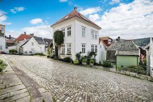 een geplaveide straat met een wit huis en huizen bij Det grønne huset i Verftsgaten in Bergen